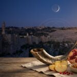Shofar, romã, maçã e mel sob a luz simbólica da Lua Nova em uma composição sobre Rosh Hashaná.