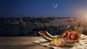 Shofar, romã, maçã e mel sob a luz simbólica da Lua Nova em uma composição sobre Rosh Hashaná.